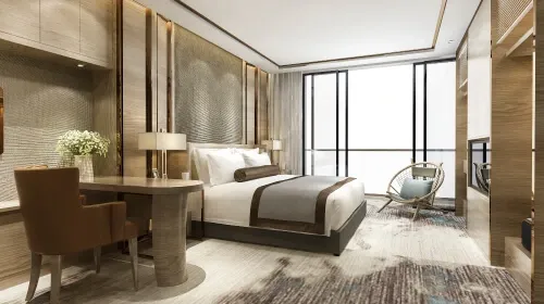 Modern hotel room with warm wood paneling, a large bed, a work desk, and a floor-to-ceiling window